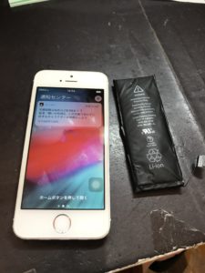 取り出したバッテリーと修理後のiPhone5s