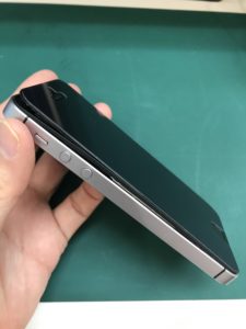 左側面からフロントパネルが浮いてるiPhoneSE